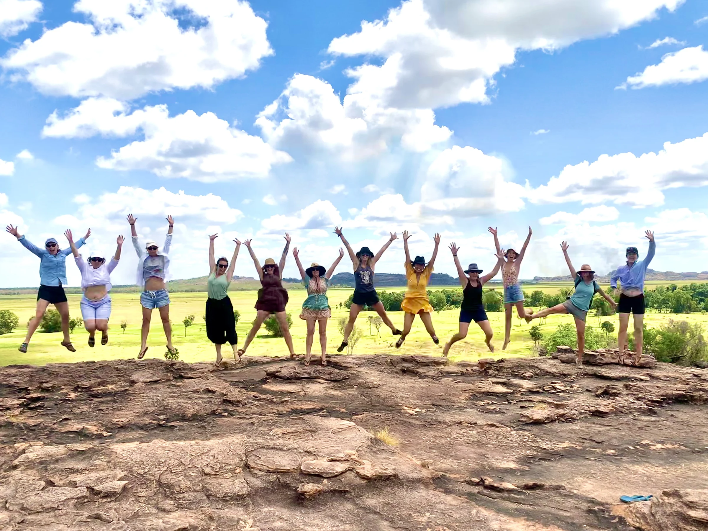 Women jumping for joy on red earth
