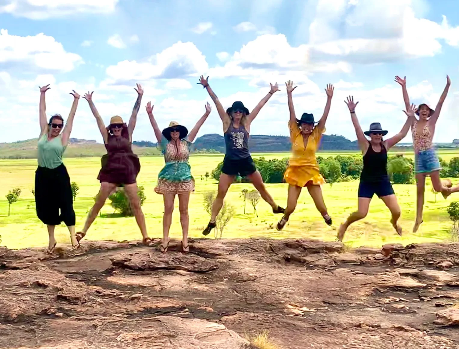 Women jumping for joy under a huge sky
