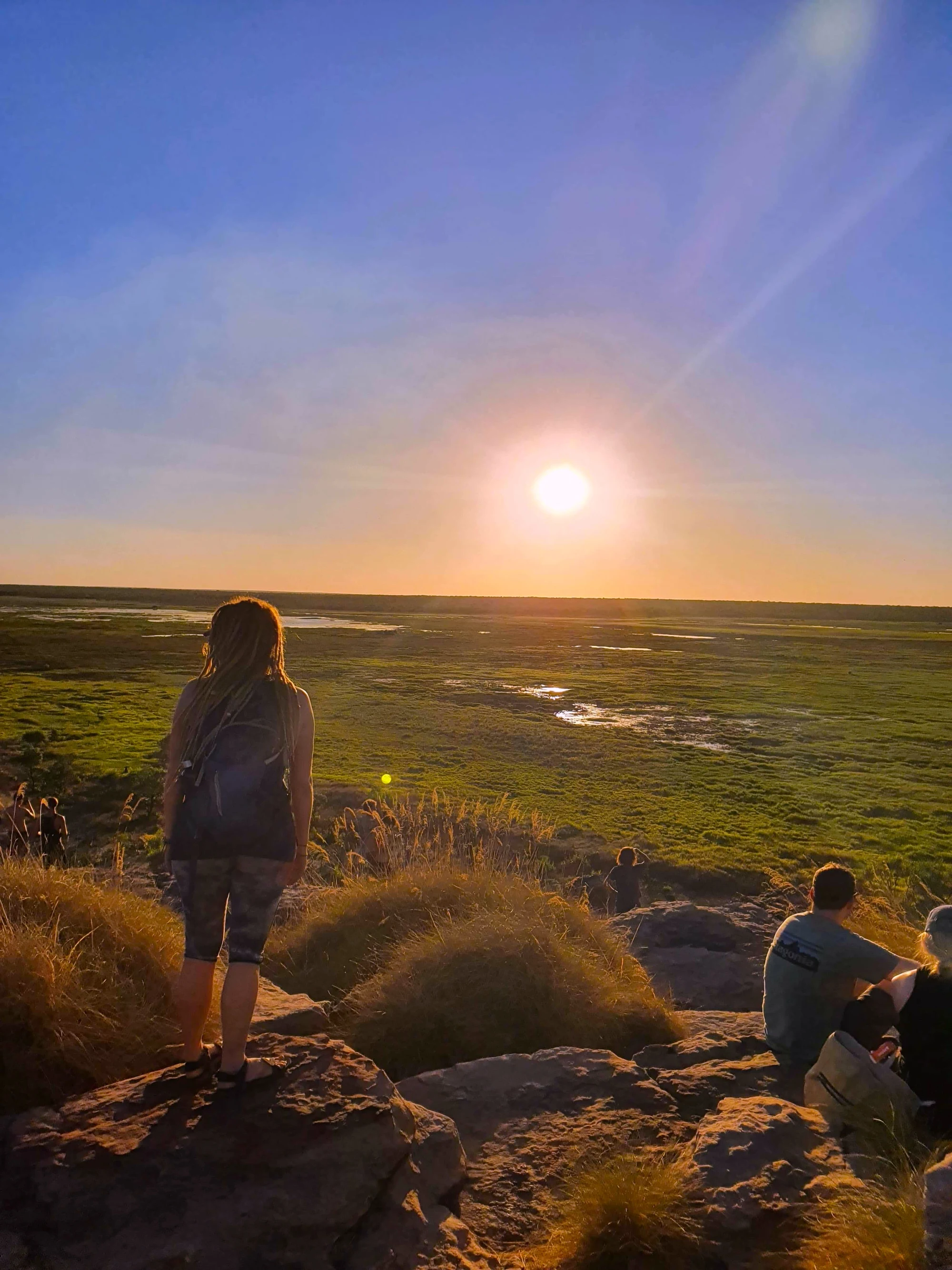 A woman on a rock at sunset